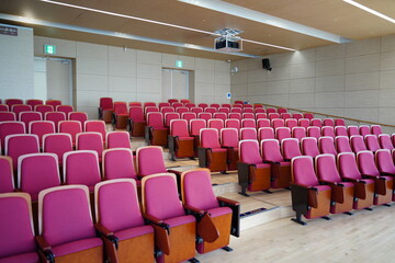 Naklejka premium Empty Conference Hall Auditorium with Red Chairs