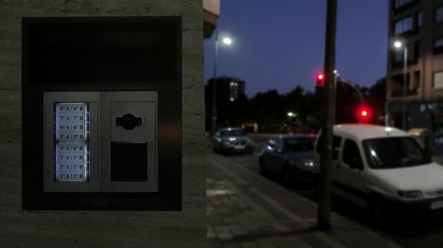 Urban Night Street Scene With Intercom Panel And Blurred Traffic Lights Below