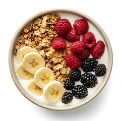 A healthy breakfast bowl featuring yogurt granola sliced bananas raspberries and blackberries