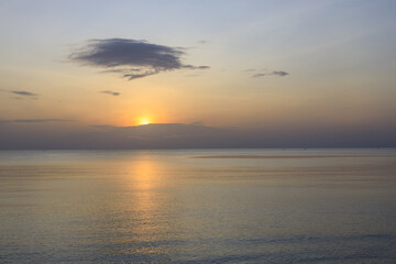 Obraz premium The sky is a beautiful orange color as the sun sets over the ocean