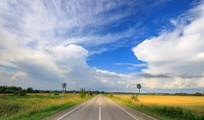 Fototapeta premium Road with a clear blue sky and a few birds flying in the background