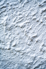 Close-up of a white stucco plaster wall with a rough, uneven texture. The neutral surface makes it ideal for use as a background, design element, or texture overlay in creative projects.
