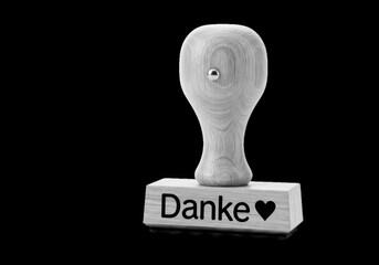 Wooden rubber stamp with the german word danke and a heart isolated on transparent background
