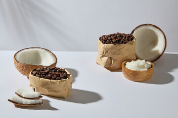 Fresh coconuts, roasted coffee beans and bowl of butte. White clean background emphasizes natural beauty and skincare visuals. Space for design product