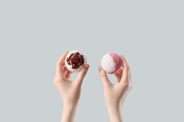 Female hands with bath bombs on white background