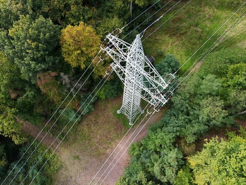 Aerial Drone View of High-Voltage Power Line Tower in Forest Landscape