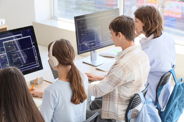 Group of teenage students studying at school computer lab, back view