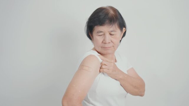 Elderly Woman with bandage after received vaccine. Vaccination and Immunization for Influenza, Herpes Zoster, Tetanus, Covid 19 booster, Dengue, Encephalitis, Rabies, Pneumococcal, IPD, RSV Vaccines