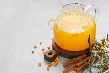 Sea buckthorn tea with cinnamon in a glass teapot