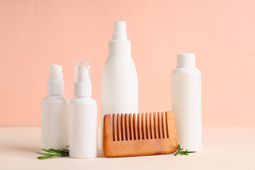 Hair comb, rosemary twigs and bottles of cosmetic products on pink background, closeup