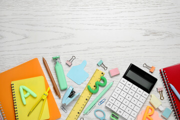 Calculator and different school supplies on white wooden background, closeup