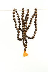 Fototapeta premium Wooden mala beads hanging against a white background, representing spirituality and mindfulness