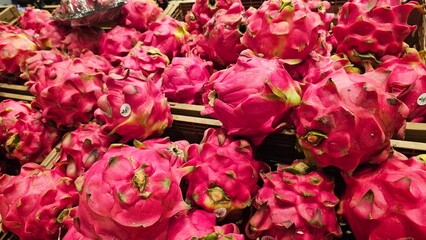 Vibrant Dragon Fruit Pile at Market. Fresh Pitaya Display for Sale.