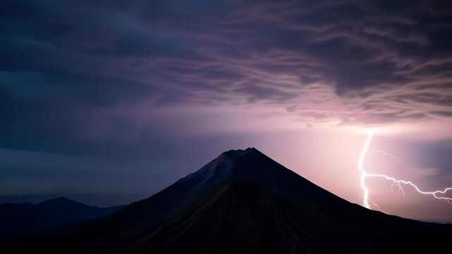 Dramatic lightning strike illuminates volcanic silhouette at night