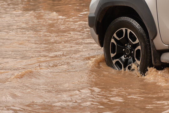 Muddy rain from a heavy rainy season flooded main roads connecting the district, making it difficult for cars to pass through and causing engine failures, in motion, car insurance concept, in motion.