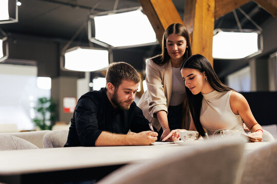 Business team reviewing and signing documents together at a table