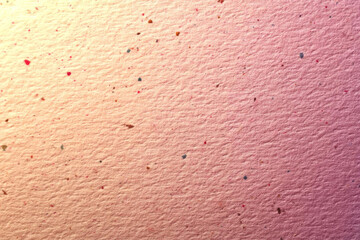Textured paper with colorful specks creates vibrant background for art projects