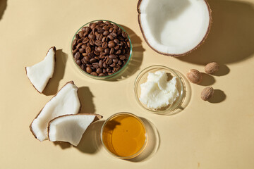 Coconut shell, roasted beans, creamy shea butter on petri dish, and honey in glass. Warm aesthetic suited for beauty, spa, and organic cosmetic product presentations.