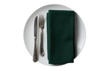 White plate with silverware and dark green napkin