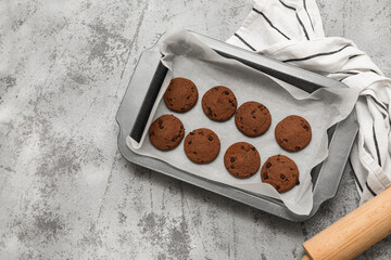 Baking tray with tasty chocolate cookies on grey grunge background
