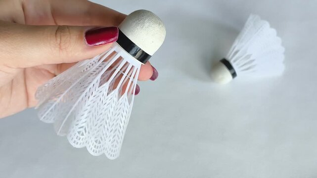 Vlonaczyk in a woman's hand on a white background close-up. Badminton shuttlecocks. Sports games