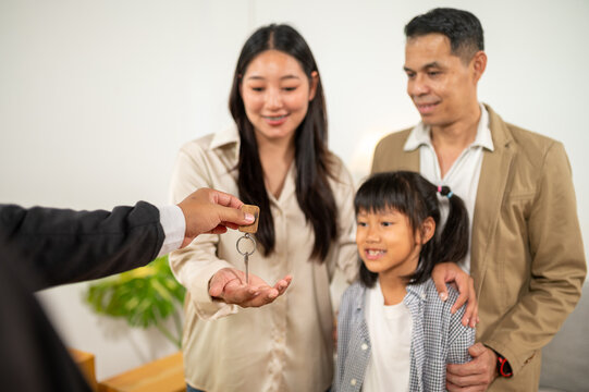 Key handover: Family receives the key of their new house or property, symbolizes a new beginning and the achievement of a life goal.