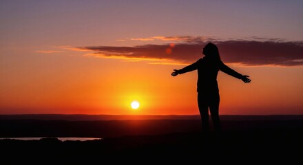 Silhouette of a woman standing with her arms wide open facing a vibrant sunset sky over a tranquil landscape, symbolizing freedom and spirituality