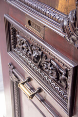 Artisan details of an antique wooden door with ornate metal mailbox and golden handle, glowing under warm afternoon light in Puebla, Mexico. A timeless expression of craftsmanship and architectural be