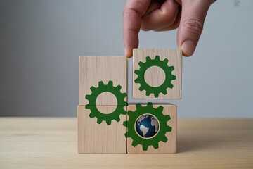 Hand connecting wooden blocks with green gears and earth icon for eco-friendly business concepts