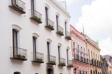 Historic colonial buildings along 5 Sur street in Puebla, Mexico, showcasing ornate facades and wrought iron balconies from a clean, distraction-free perspective.
