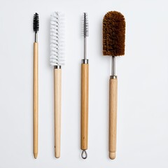 Assorted cleaning brushes with wooden handles arranged on a stark white backdrop