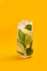 Mojito in a glass on a yellow background.