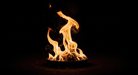 Fototapeta premium Fiery flames in a dark metal bowl