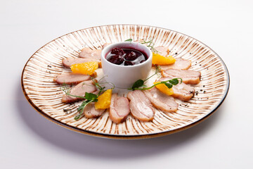 Duck breast with tangerines on a plate.