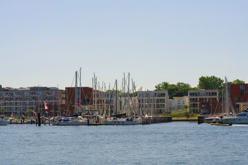 Obraz premium Sailboats gracefully positioned in a Modern Marina that beautifully features Waterfront Apartments
