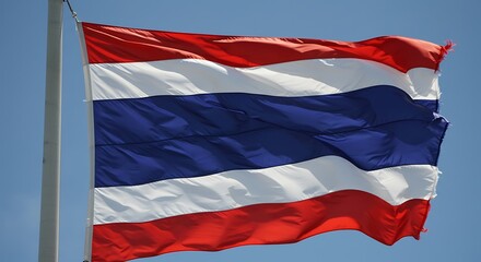 Naklejka premium Thailand national flag waving against clear blue sky symbol of patriotism