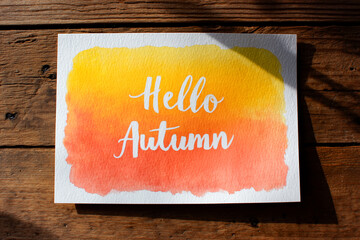 Welcome autumn with a warm watercolor postcard featuring "Hello Autumn" in elegant script on cozy textured paper.