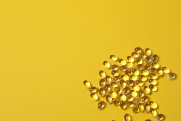 Vitamin pills and bottle on yellow background, top view. Space for text
