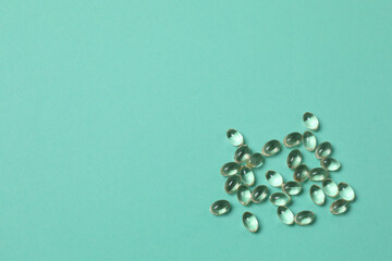 Vitamin pills and bottle on green background, top view. Space for text
