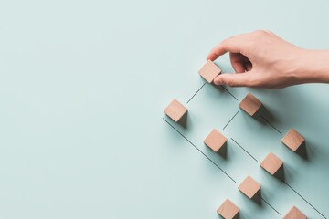 Hand placing a wooden cube at the top of a hierarchical structure, illustrating business management, process organization, and team building