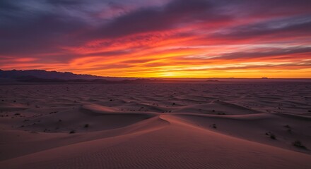 Vibrant sunset over desert landscape with dunes and colorful sky