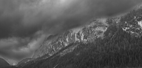 Dramatic black and white mountain panorama with rugged peaks and stormy clouds