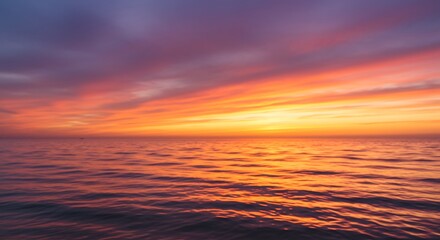 Vibrant sunset sky over calm ocean water with colorful reflections