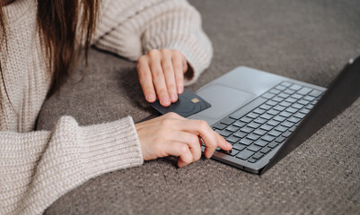 Woman at home shopping online on laptop with credit card