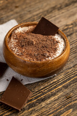 sweet yogurt in a bowl with chocolate crumbs, chocolate pieces in milk yogurt, sweet dessert with chocolate flavor