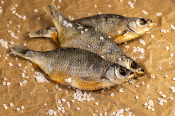 salt and dried fish for long-term storage by dehydrating whole fish in the sun, dried fish in scales ready for human consumption, sprinkled with white salt crystals
