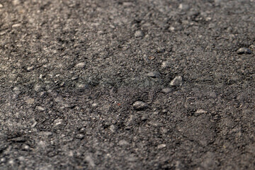 details of the black asphalt on the highway, part of the newly built asphalt highway made of bitumen with crushed stone and sand