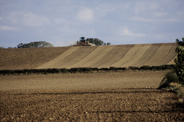 Working tractor pulling a set of Discs over soil bed UK North Bedfordshire 1998