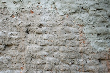 Weathered wall with peeling plaster and exposed brick. Rough grunge texture background ideal for urban, industrial, vintage, or architectural design use. Natural decay and distressed surface detail.