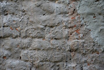 Weathered wall with peeling plaster and exposed brick. Rough grunge texture background ideal for urban, industrial, vintage, or architectural design use. Natural decay and distressed surface detail.